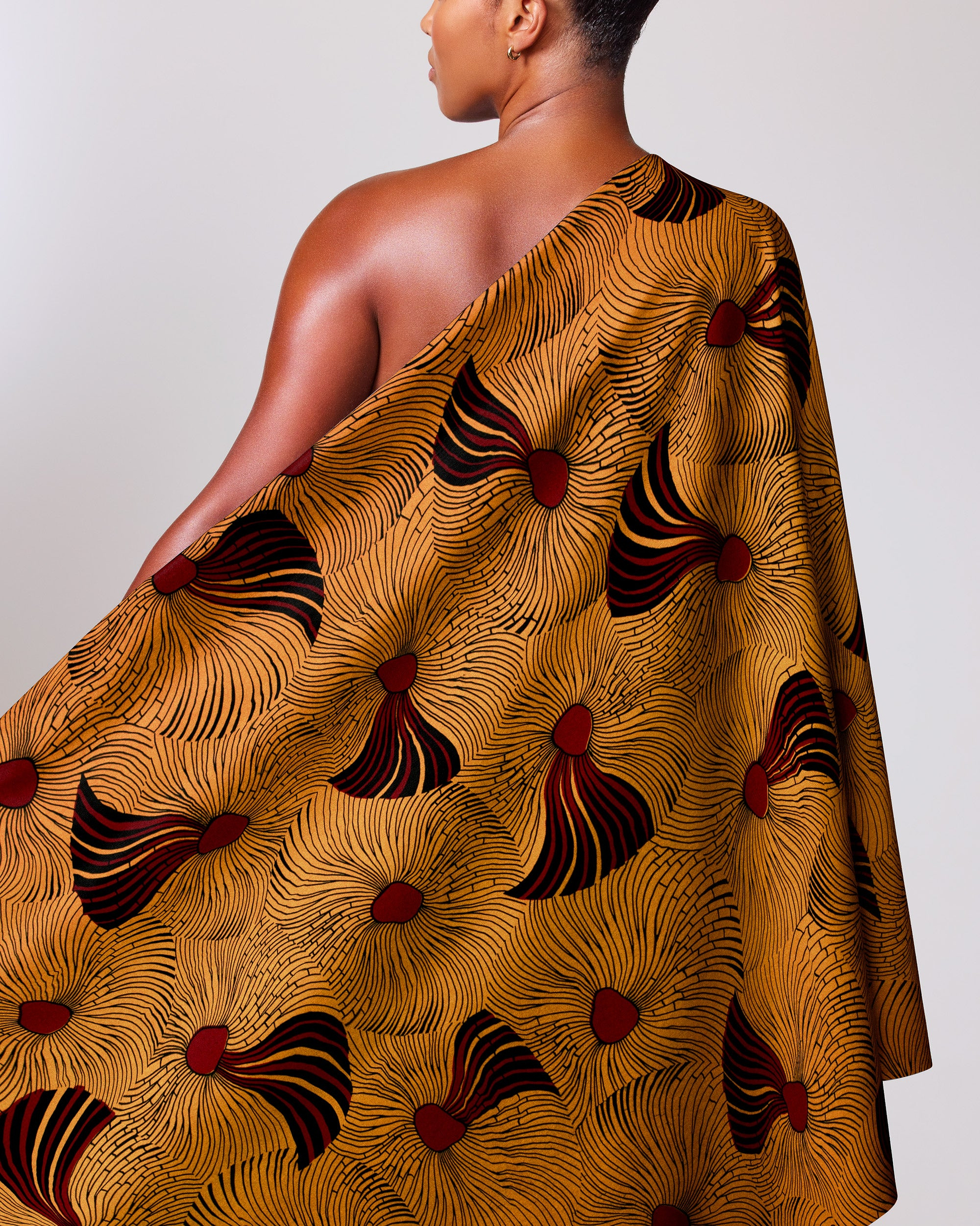 Woman wears one-shoulder dress made wax hollandais vl03586.098