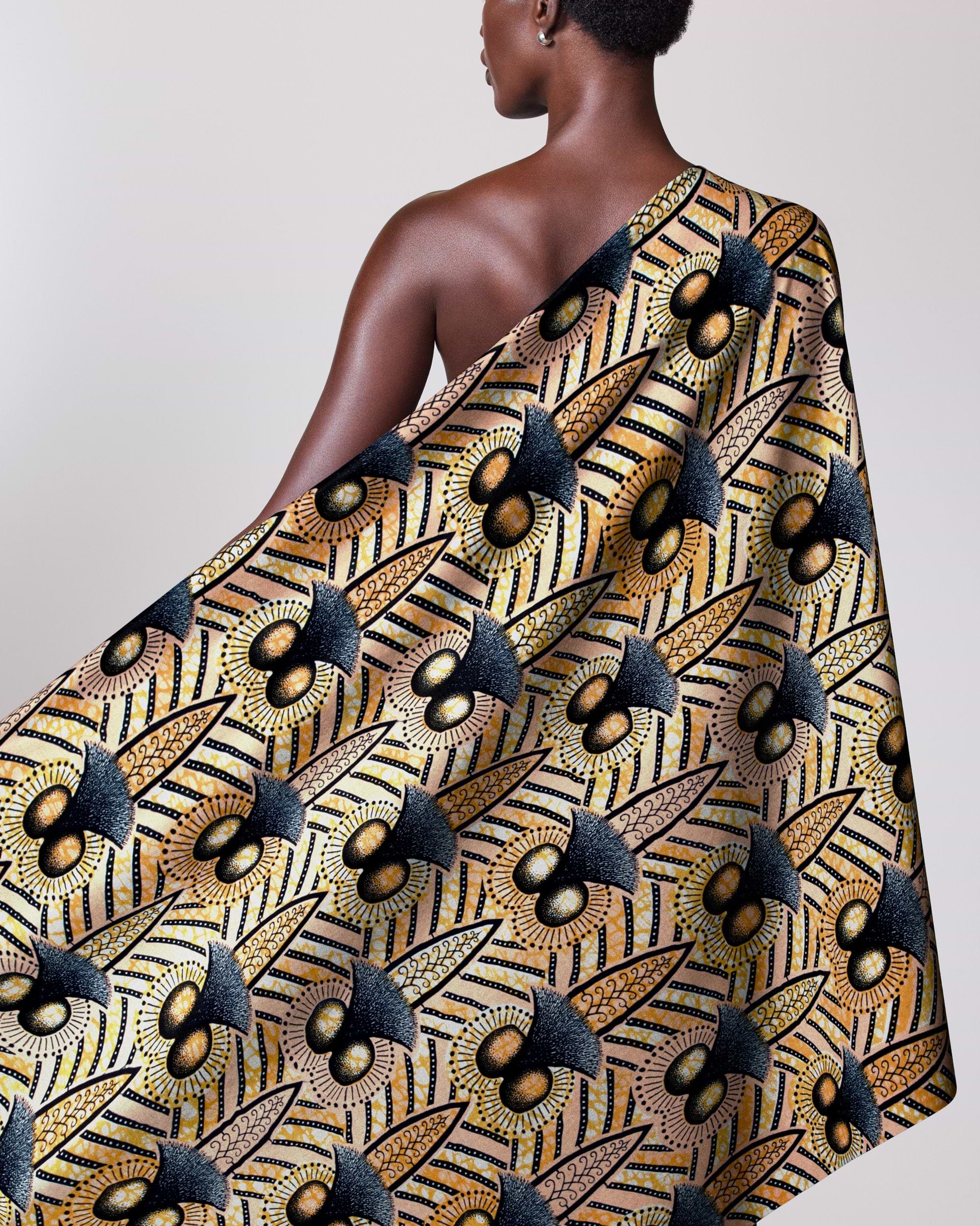 Woman wears vibrant one-shoulder wrap wax hollandais vlw9321.001