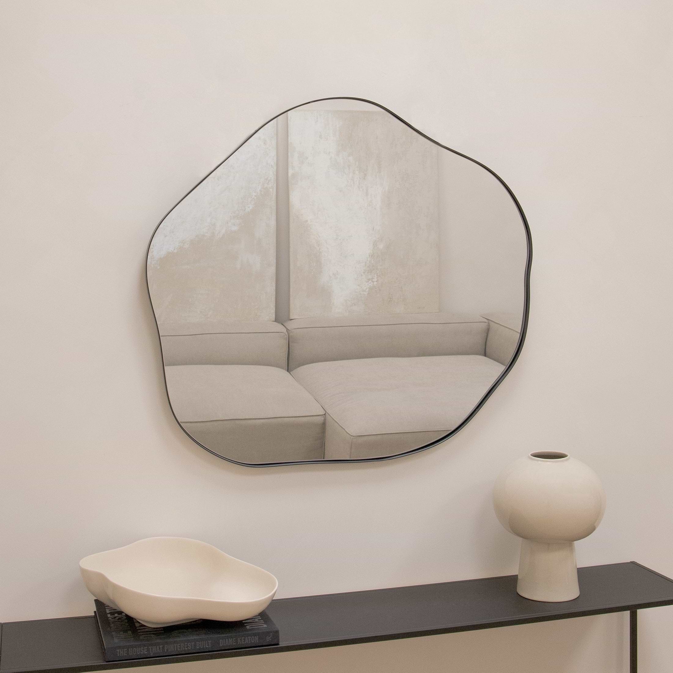 Irregular wall mirror above a console table