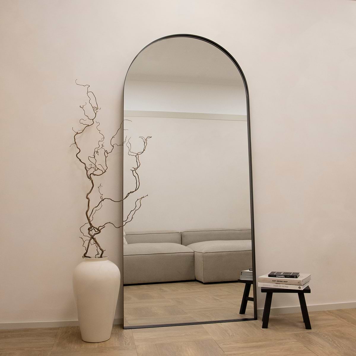 Full length arched black extra large metal mirror leaning against wall