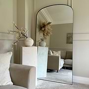Full length black large metal mirror leaning against wall