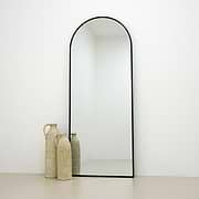 Black Full Length Arched Metal Mirror beside ceramic vases