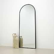 Black Full Length Arched Metal Mirror beside ceramic vases
