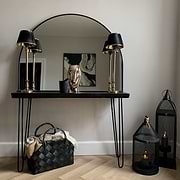 Black Wide Arched Metal Overmantle Mirror on console table