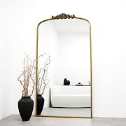 Extra large gold vintage arched metal mirror leaning against wall
