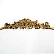 Closeup of extra large gold ornate arched metal mirror