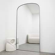 Full length black large metal mirror leaning against wall