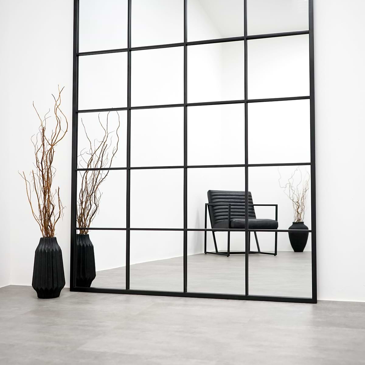 Full length XXL black industrial metal window mirror beside vase