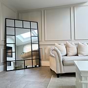 Black industrial full length metal window mirror in lounge corner