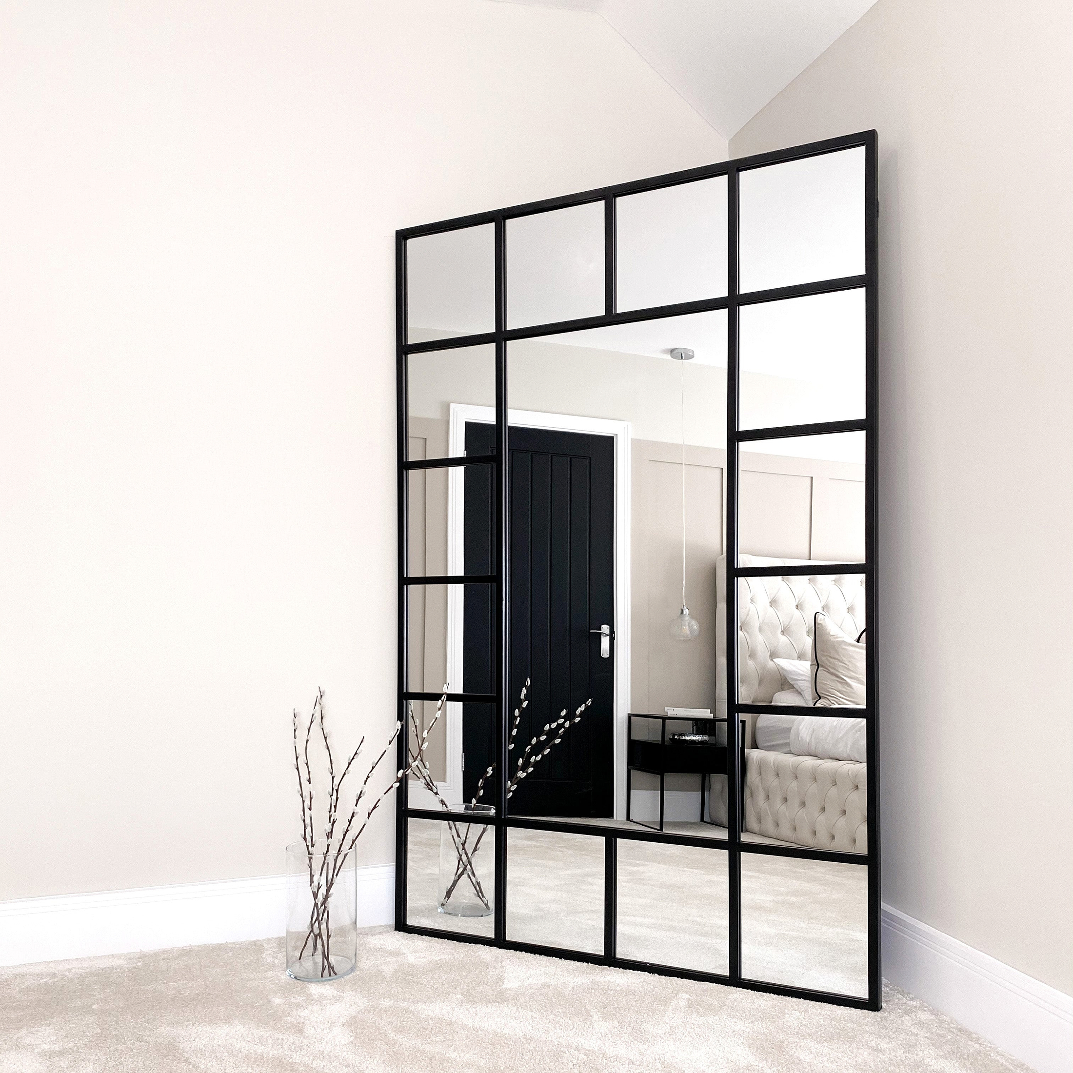 Black industrial full length metal window mirror in room corner