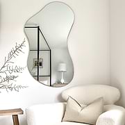 Medium Frameless Pond Mirror above chair in living room