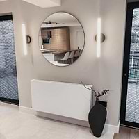 Large Frameless Round Wall Mirror between lights