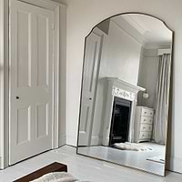 Gold Full Length Arched Metal Mirror leaning against wall in living room