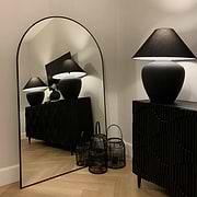 Black Full Length Arched Metal Mirror beside lamp