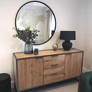 Black Metal Modern Round Wall Mirror on wall amonst vases