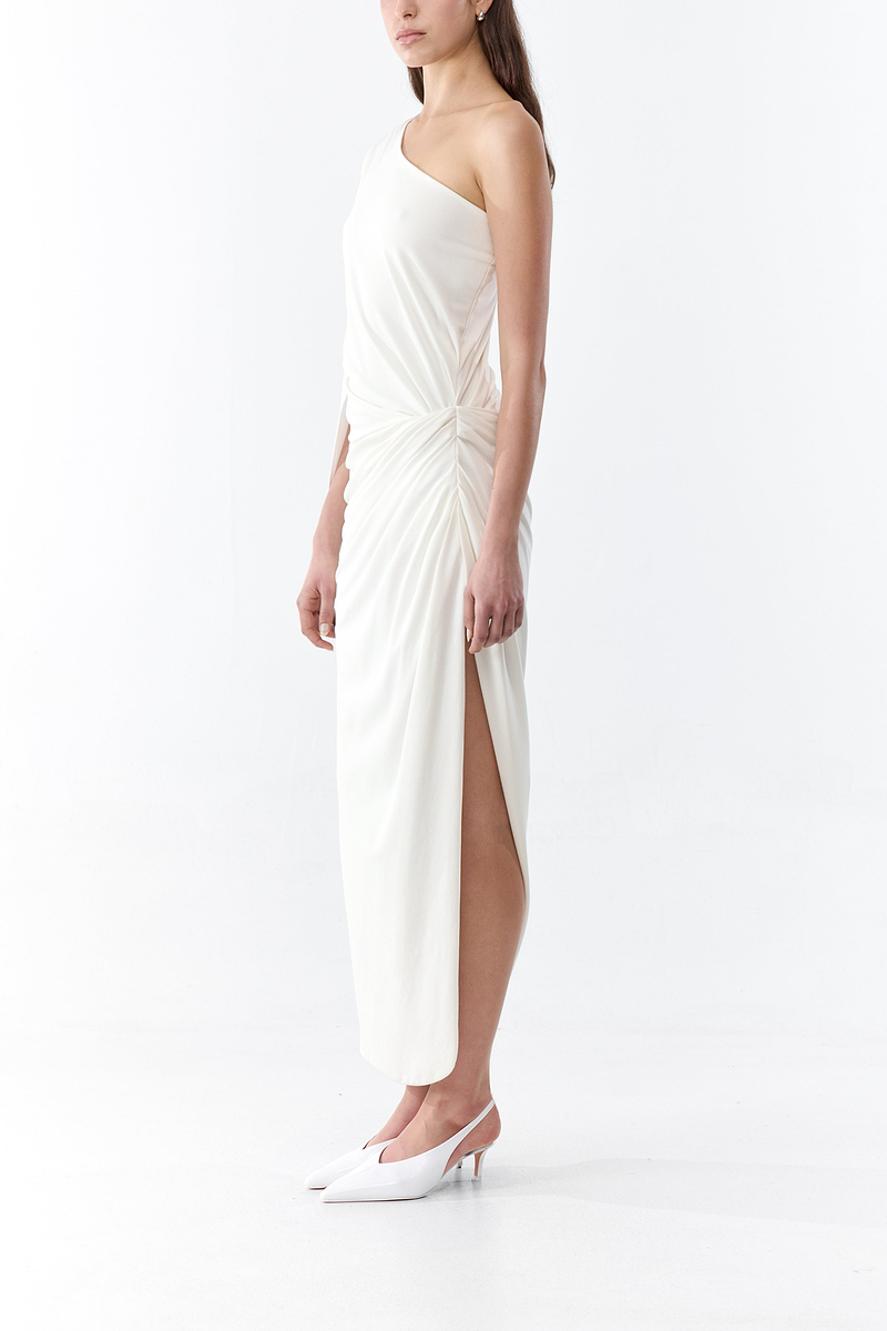 Woman wearing a white strapless dress with a high slit on a white background