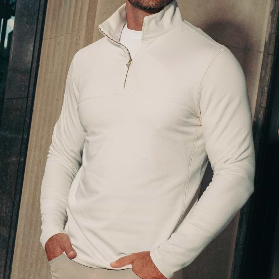 Man wearing a white quarter zip outdoors