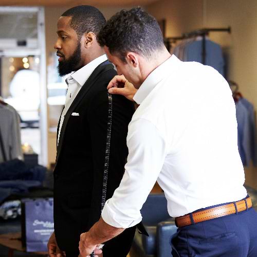 Man getting fitted for a suit in a clothing store