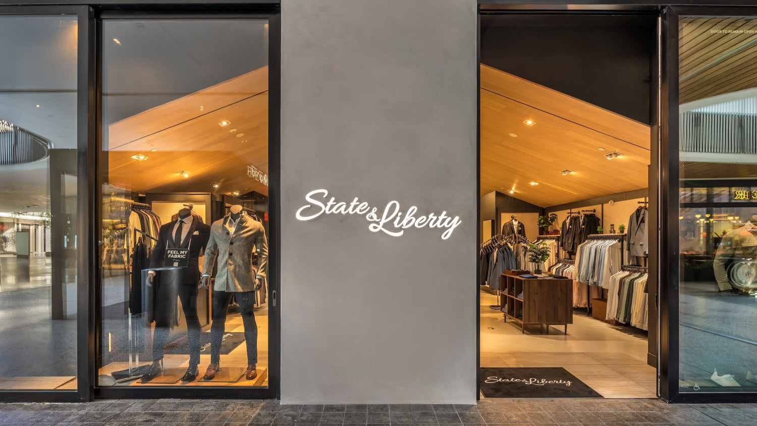 Storefront with 'State of Liberty' sign, displaying clothing inside.