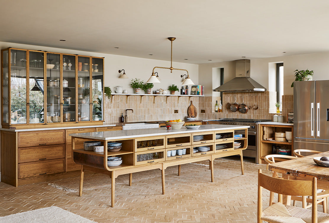 Bright, modern kitchen featuring wooden cabinetry, a large island, open shelving, and stylish pendant lights. Warm tones create a cozy atmosphere.