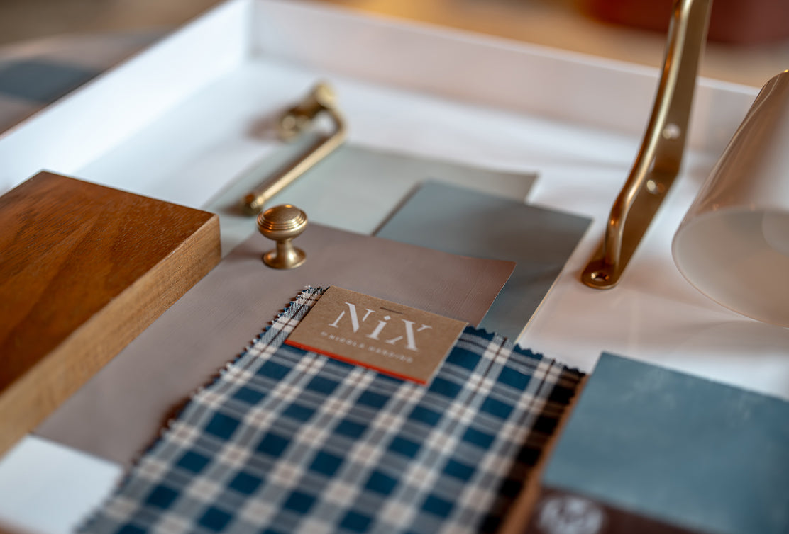 A flat layout featuring various textures and materials, including ceramic tiles, a black switch plate, and a patterned blue paper.