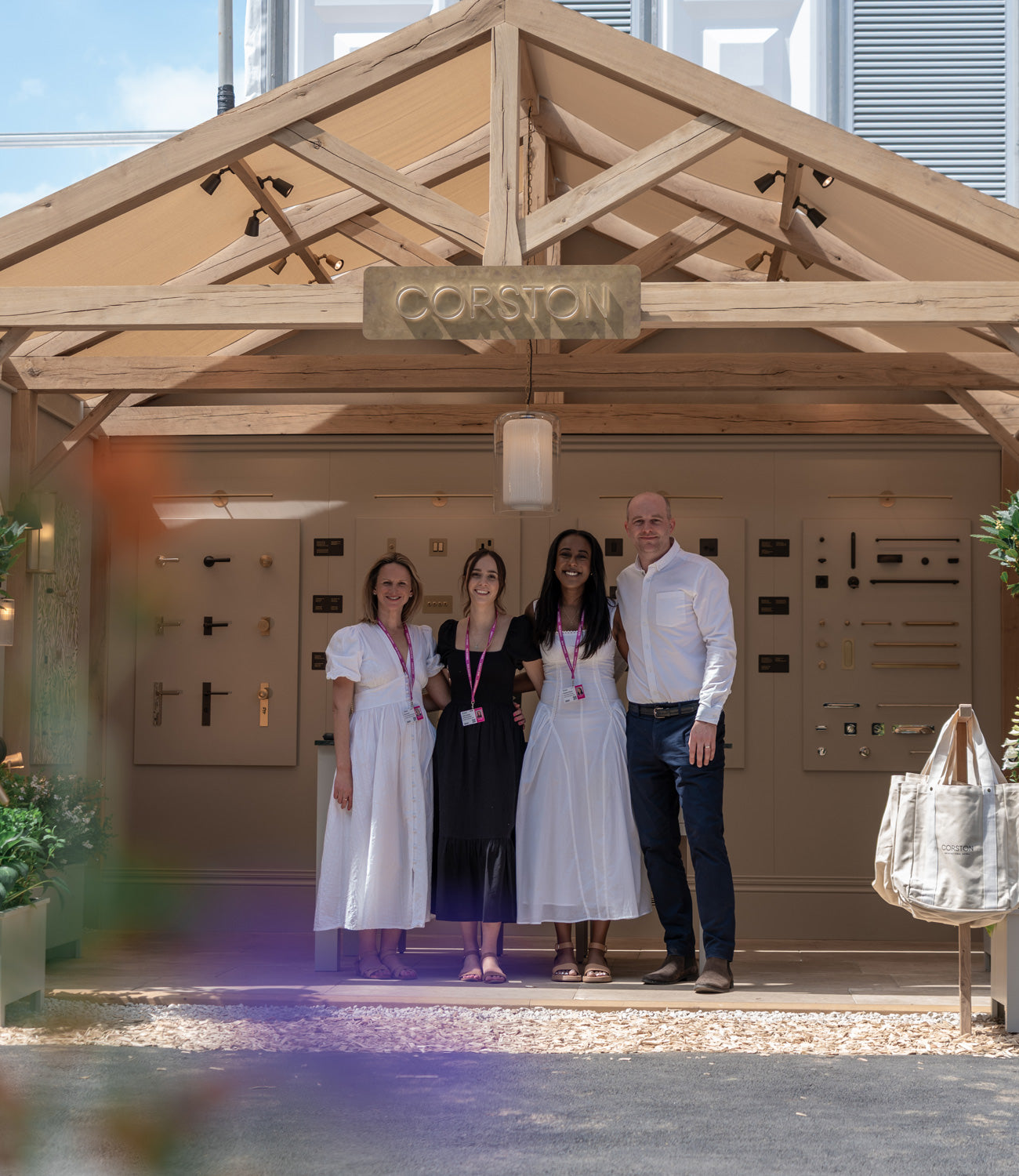 Four people stand in front of a stylish building featuring a sign that reads 