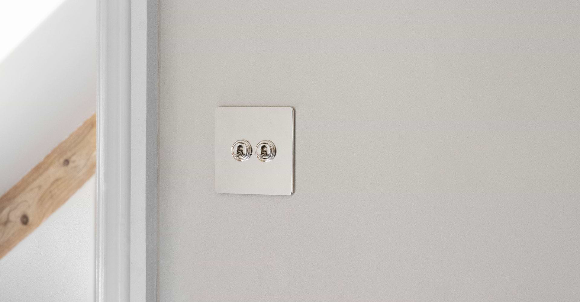 2 toggle switch in polished nickel on white wall