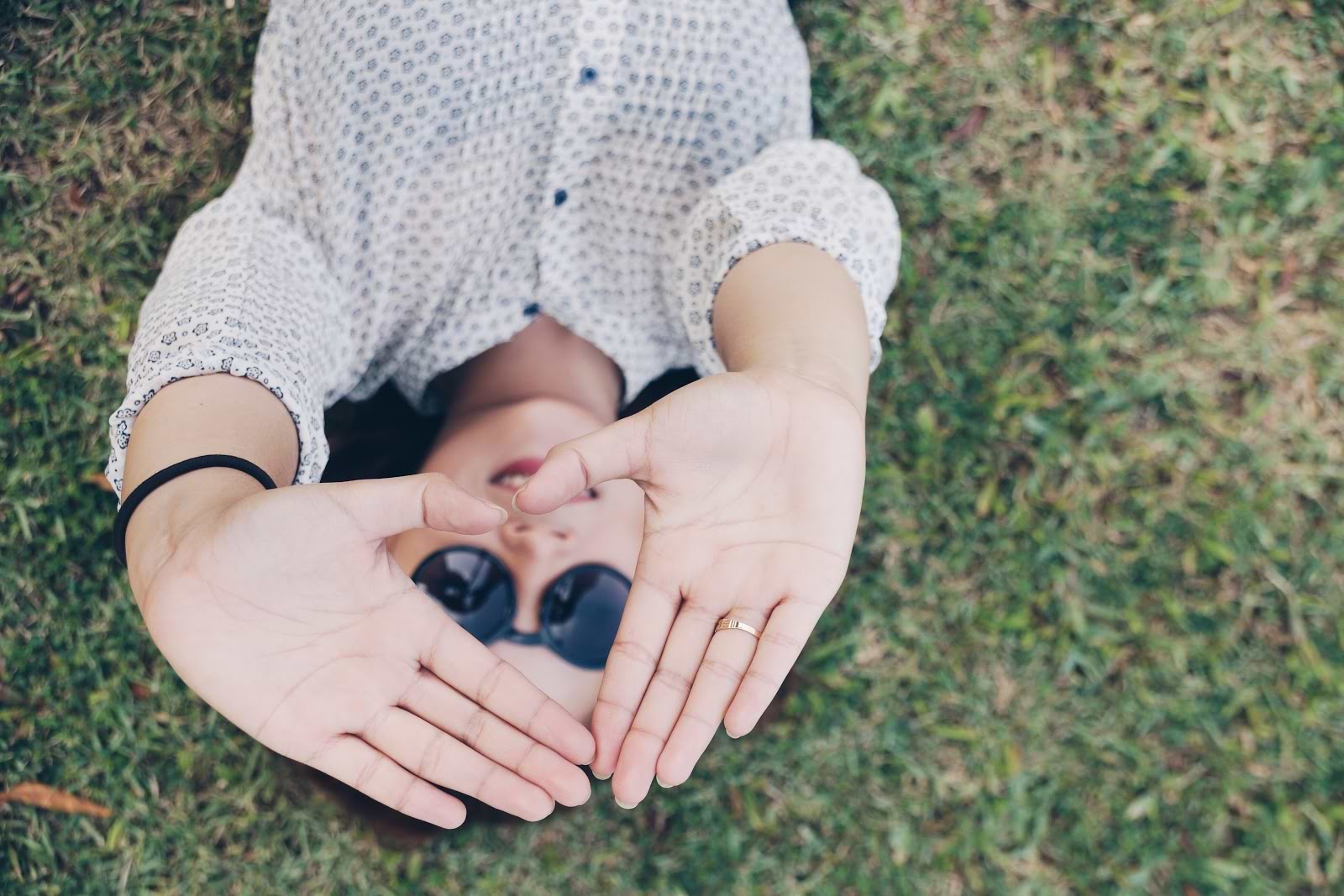 Probiotics for constipation: a woman lies in the grass and holds her hands up