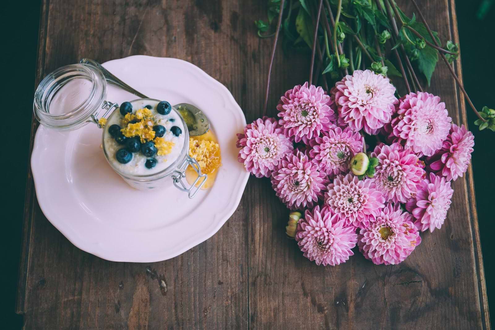 A mason jar of kefir yogurt surrounded by flowers
