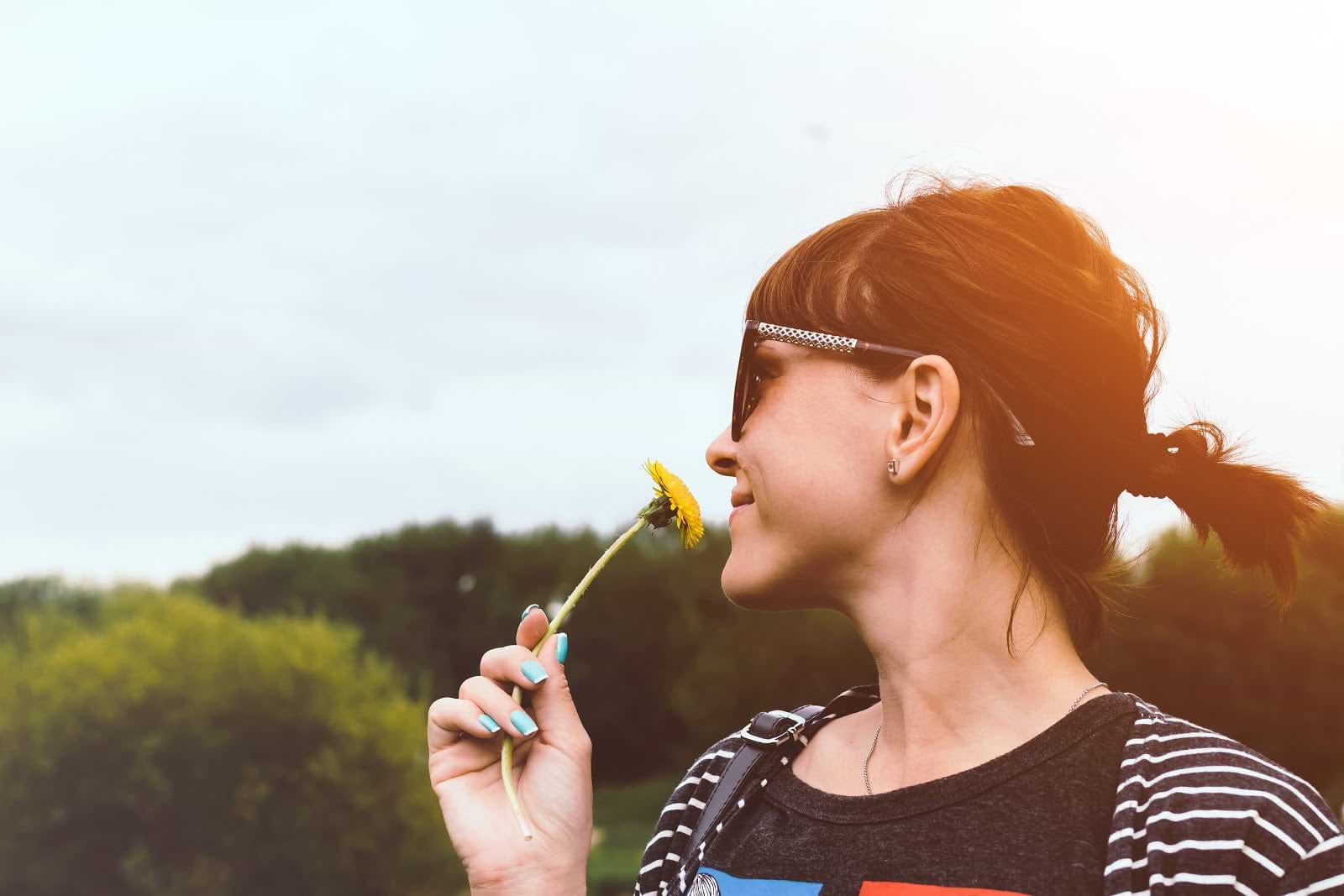 Microbiome diet: Smiling woman smells a flower
