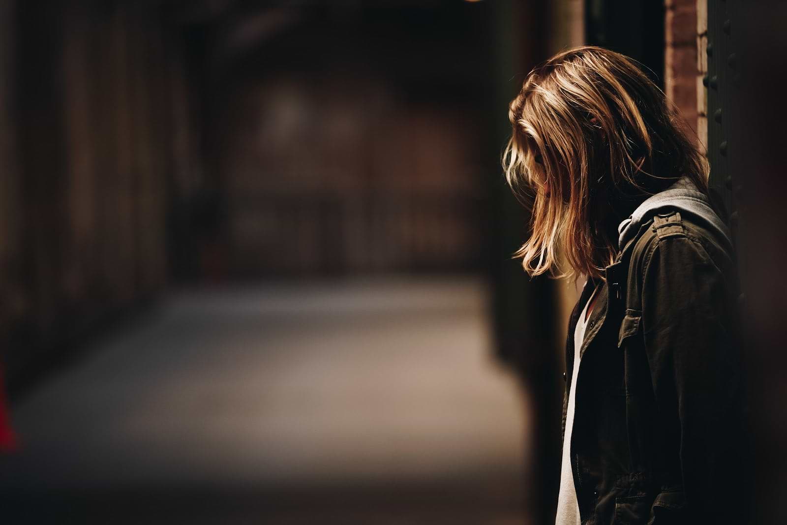 Gut dysbiosis: a woman in a dark place with her head down