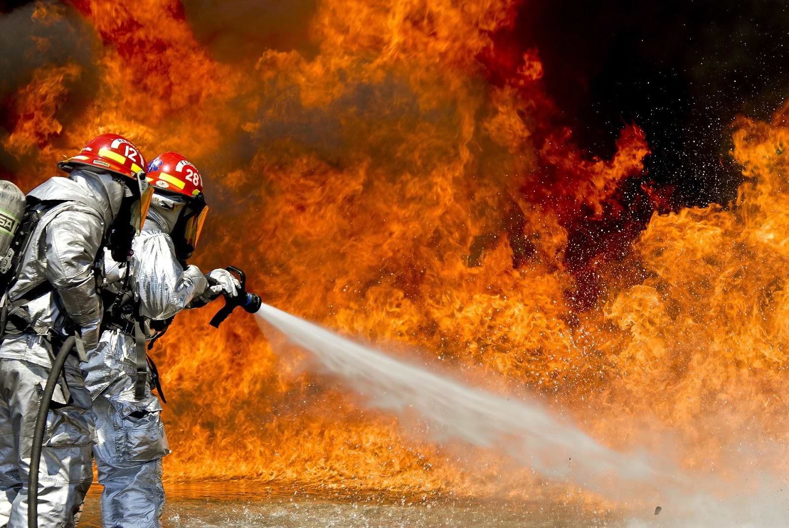 Herbs for inflammation: Fire fighters spray water on a large fire