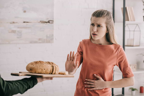 Woman saying no to gluten foods, one of the main causes of leaky gut