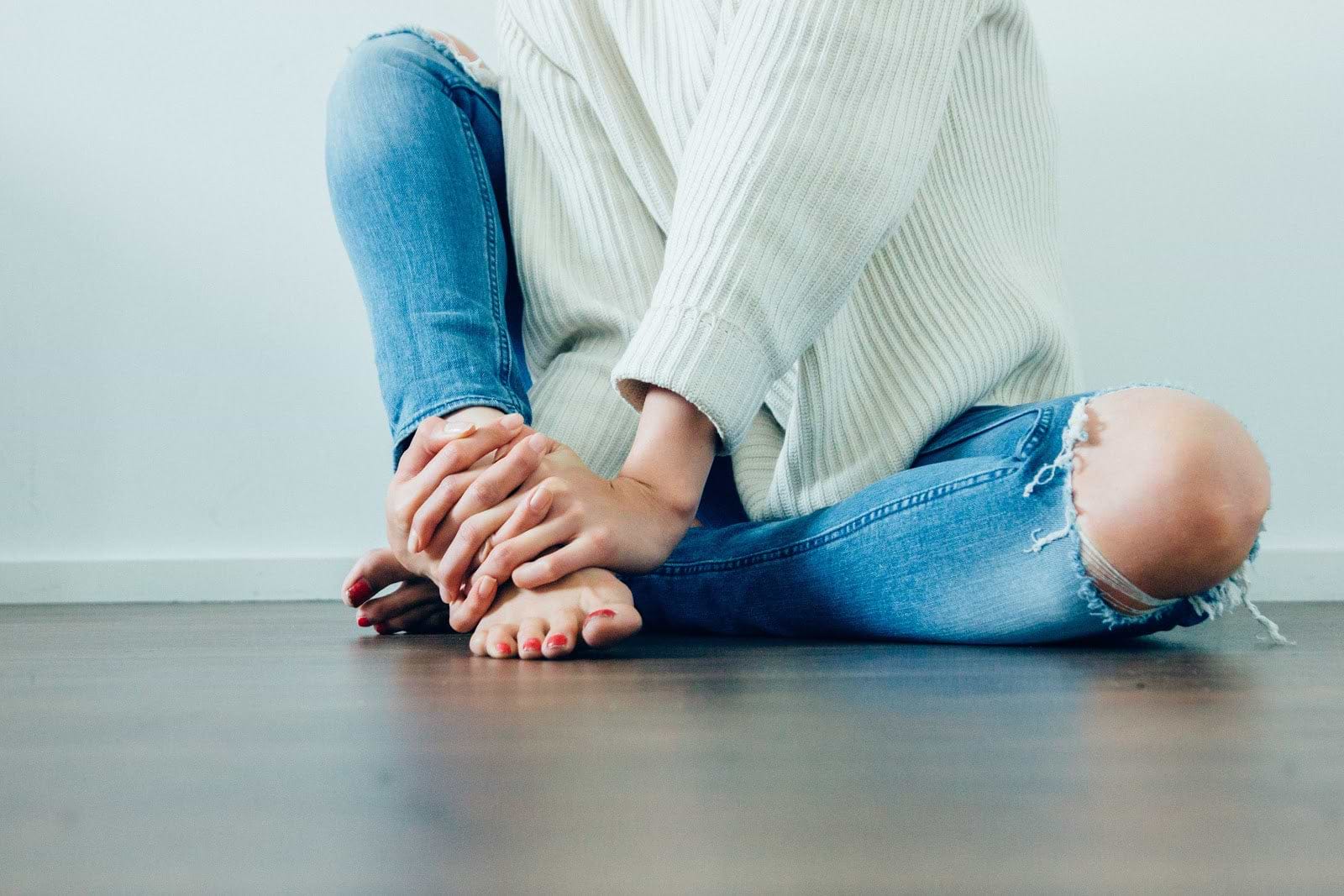 Gut dysbiosis: A woman holds her ankle