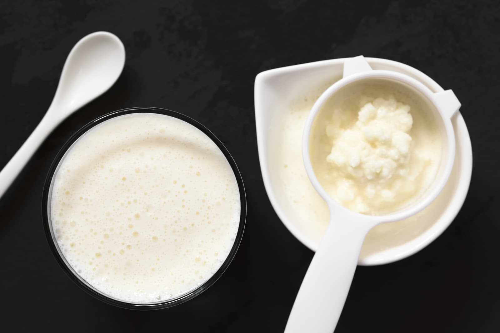 Benefits of kefir: Homemade kefir in a glass and sifting spoon