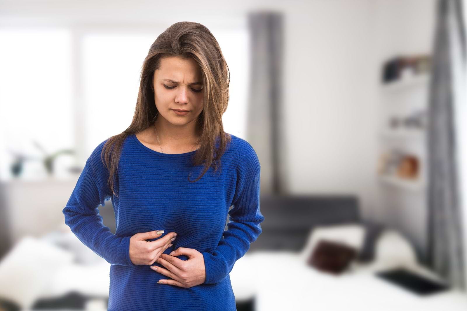 Kombucha side effects: Woman with stomach pain