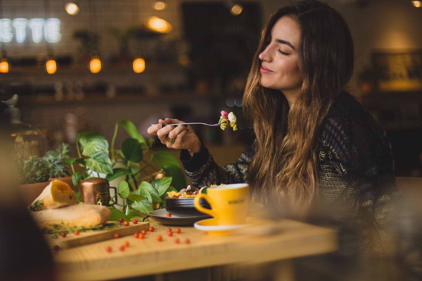 A smiling woman eating at a healthy restaurant