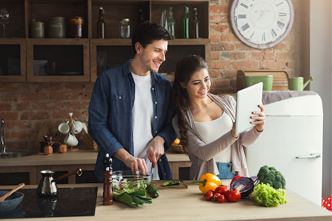 Couple reading a recipe and cooking together