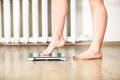 woman stepping on a scale 