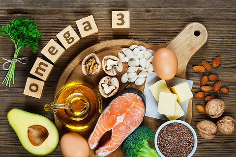 omega 3 spelled in scrabble blocks surrounded by healthy foods 