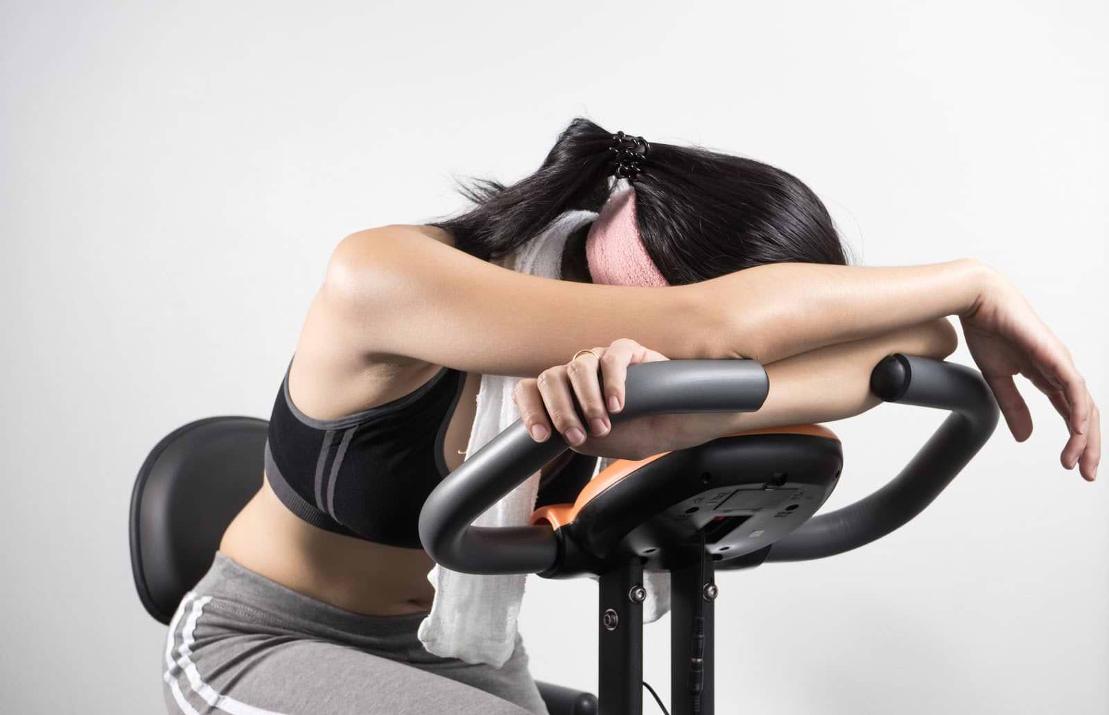 Symptoms of Low Estrogen: Tired woman on exercise bike