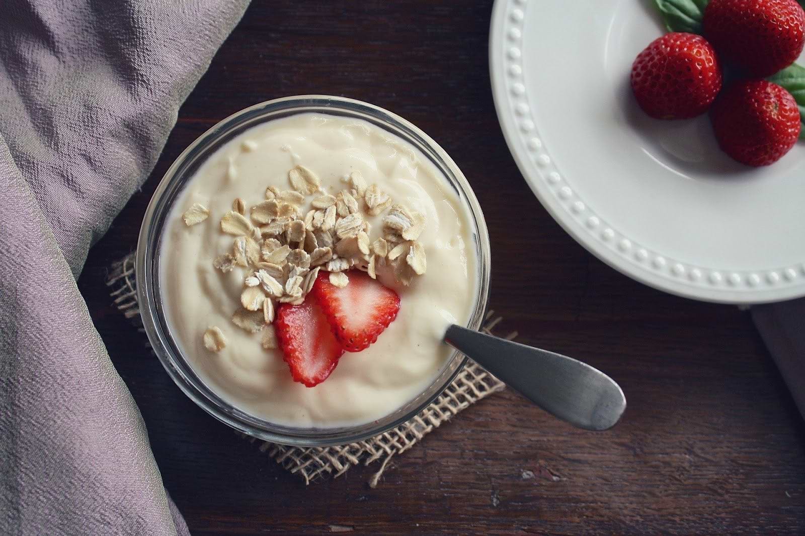 Kefir vs. yogurt: a jar of strawberry yogurt next to fresh strawberries