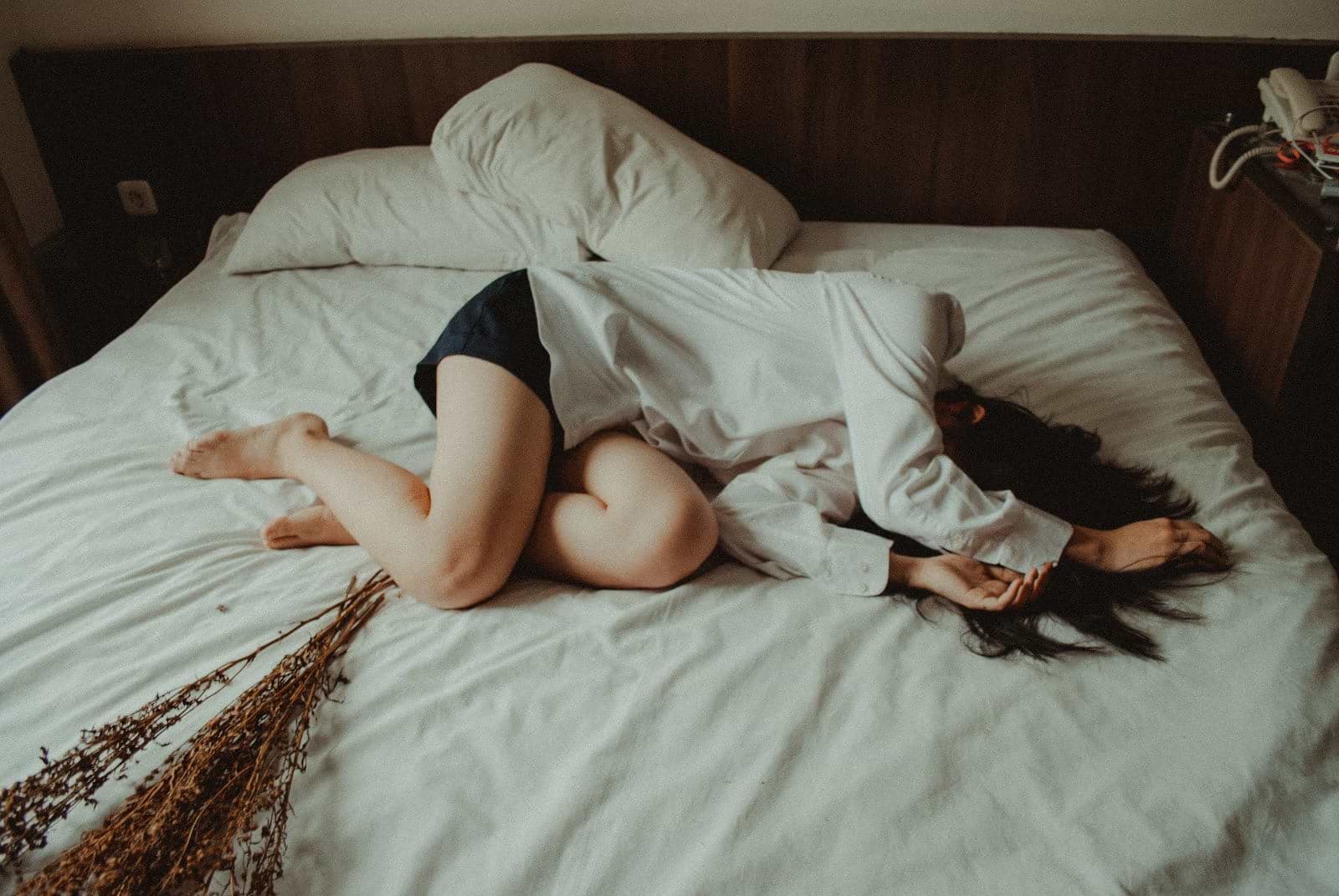 A woman curled up in bed