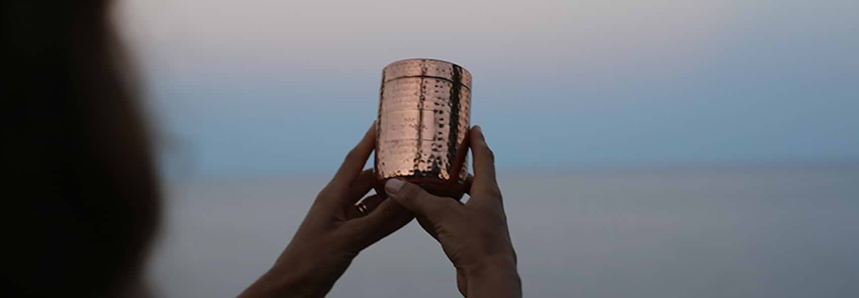 TWO HANDS HOLDING VESSEL