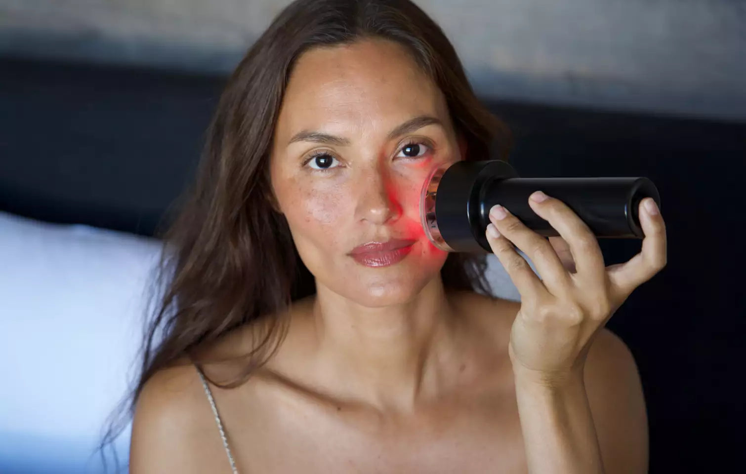 Woman using LYMA Laser Pro on face for skin rejuvenation