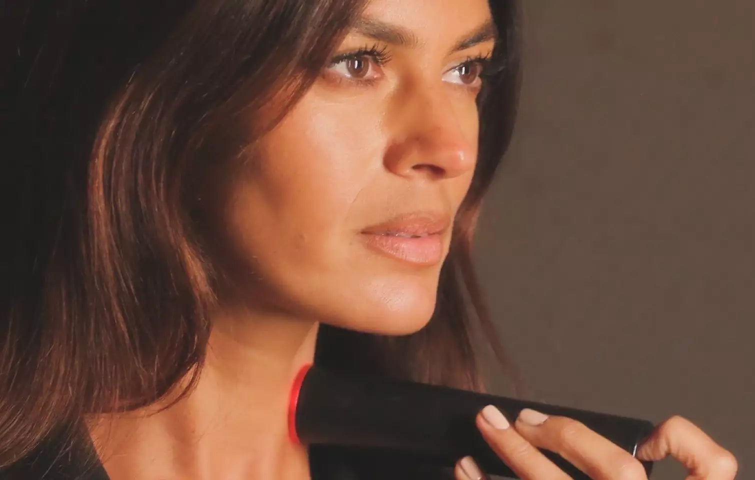 Woman using LYMA Laser Pro on neck for collagen regeneration