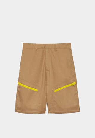 Brown MSGM Bermuda shorts in technical gabardine with pockets, high-end fashion store style.