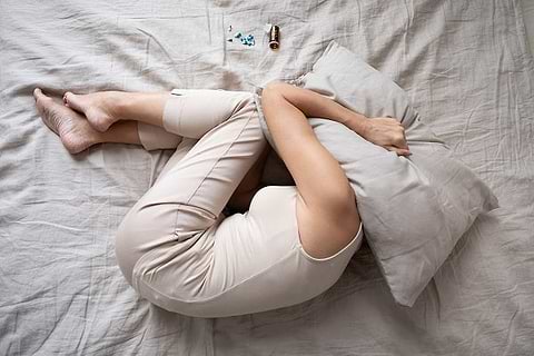 lady under pillow with insomnia