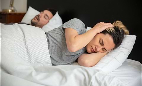 lady trying to sleep while husband is snoring