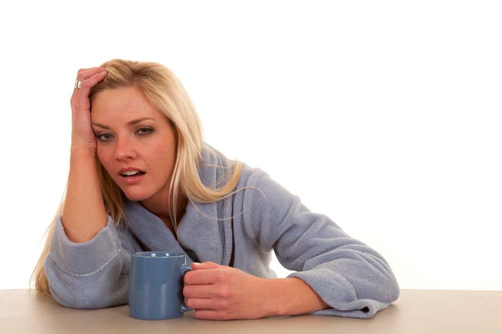 A man sitting on the edge of the bed with no energy after a bad night